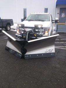 A Fisher XV2 v-plow attached to a large, white truck.