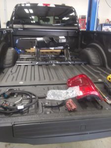 Various parts in the bed of a black truck.