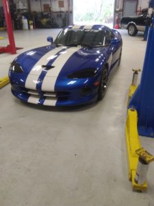 Blue sports car in the shop, ready to be worked on.