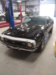 A black muscle car in the shop